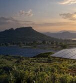 Illustrative solar panels and West African engineers in a Guinea-inspired highland landscape